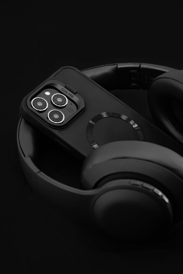 sleek-black-smartphone-and-headphones-on-dark-background-32912307