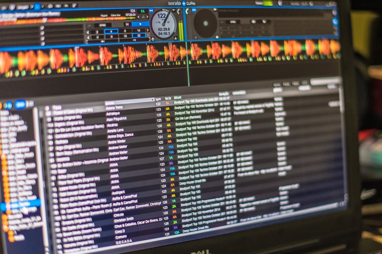 A detailed view of DJ mixing software open on a laptop screen, showcasing tracks and waveforms.